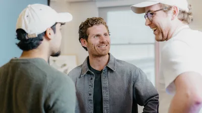 Matt Palmer talking with two people in a candid conversation